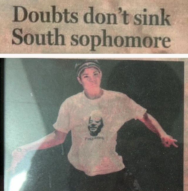 A framed newspaper clipping from the prep tennis page, reproduced as its two pieces: the headline Doubts don't sink South sophomore, and beneath it the photograph that ran beside it, a teenager in a headband and a white shirt, arms out mid-rally.
